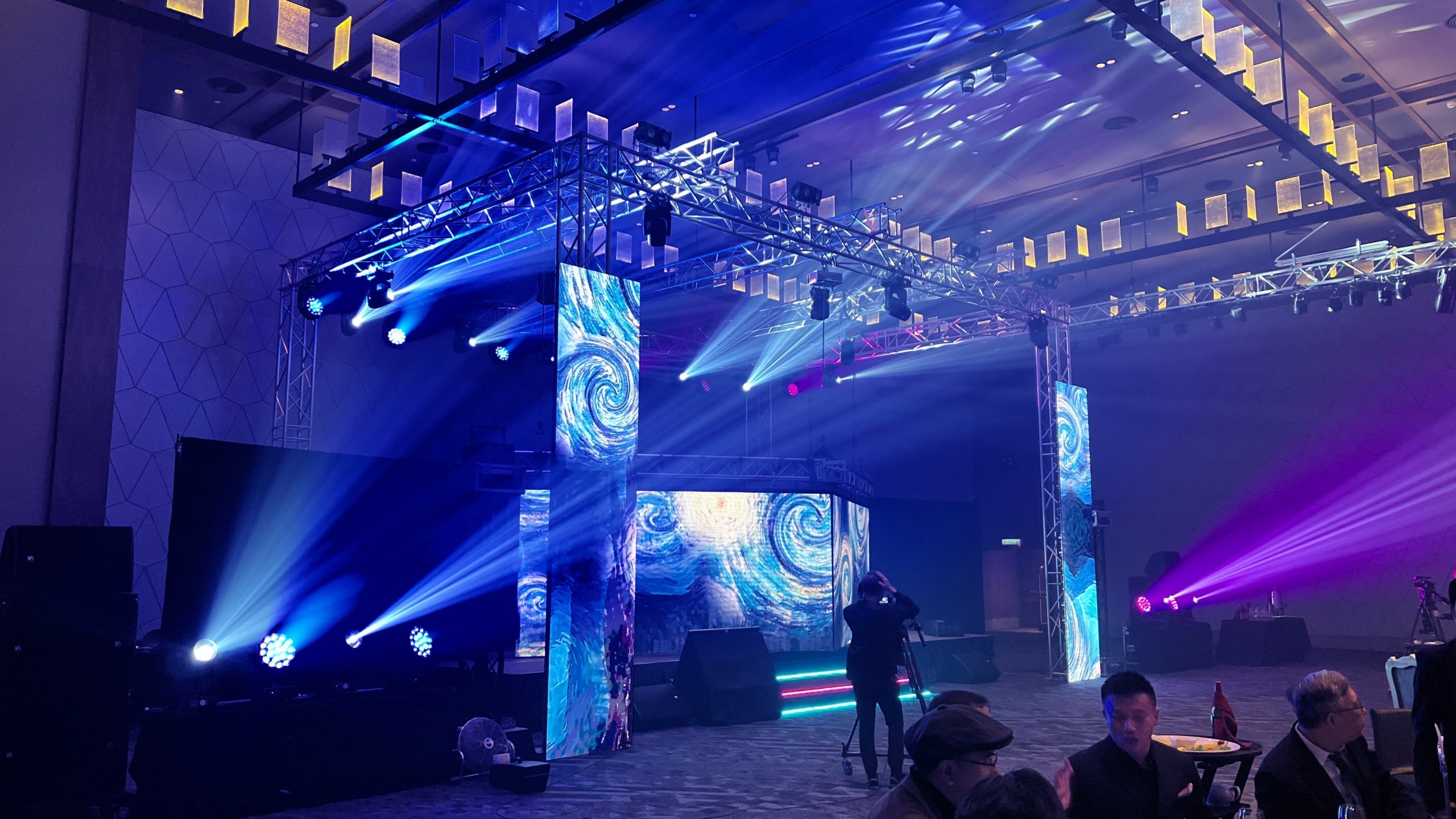 The image features LED Screen Display panels on stage to create an extra ordinary moving design experience for an event. The digital screen designs can be customized to suit the event theme.